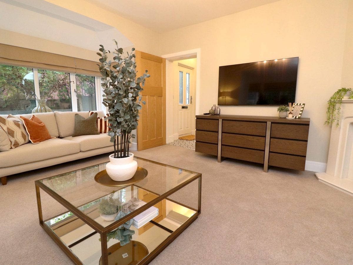 Living room with roman blinds at the bay window, cream sofa and a eucalyptus