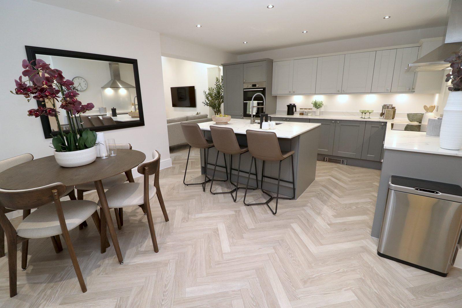 Dining table and chairs with the kitchen beyond