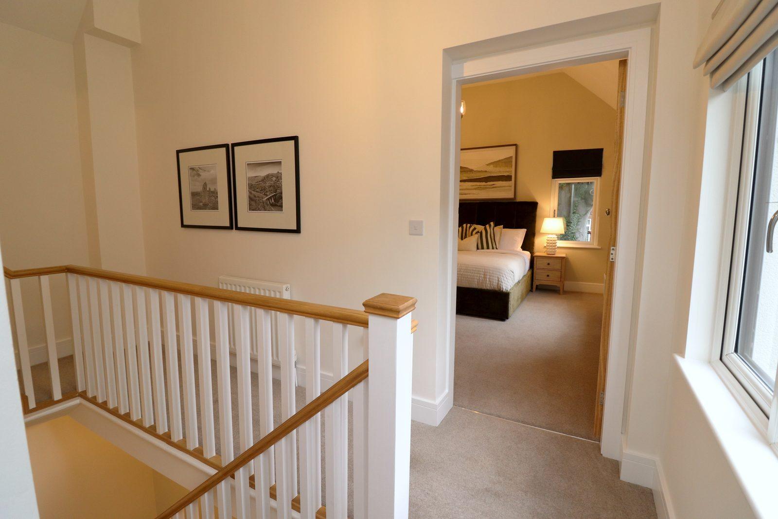 Landing: framed prints, banister and the main bedroom beyond