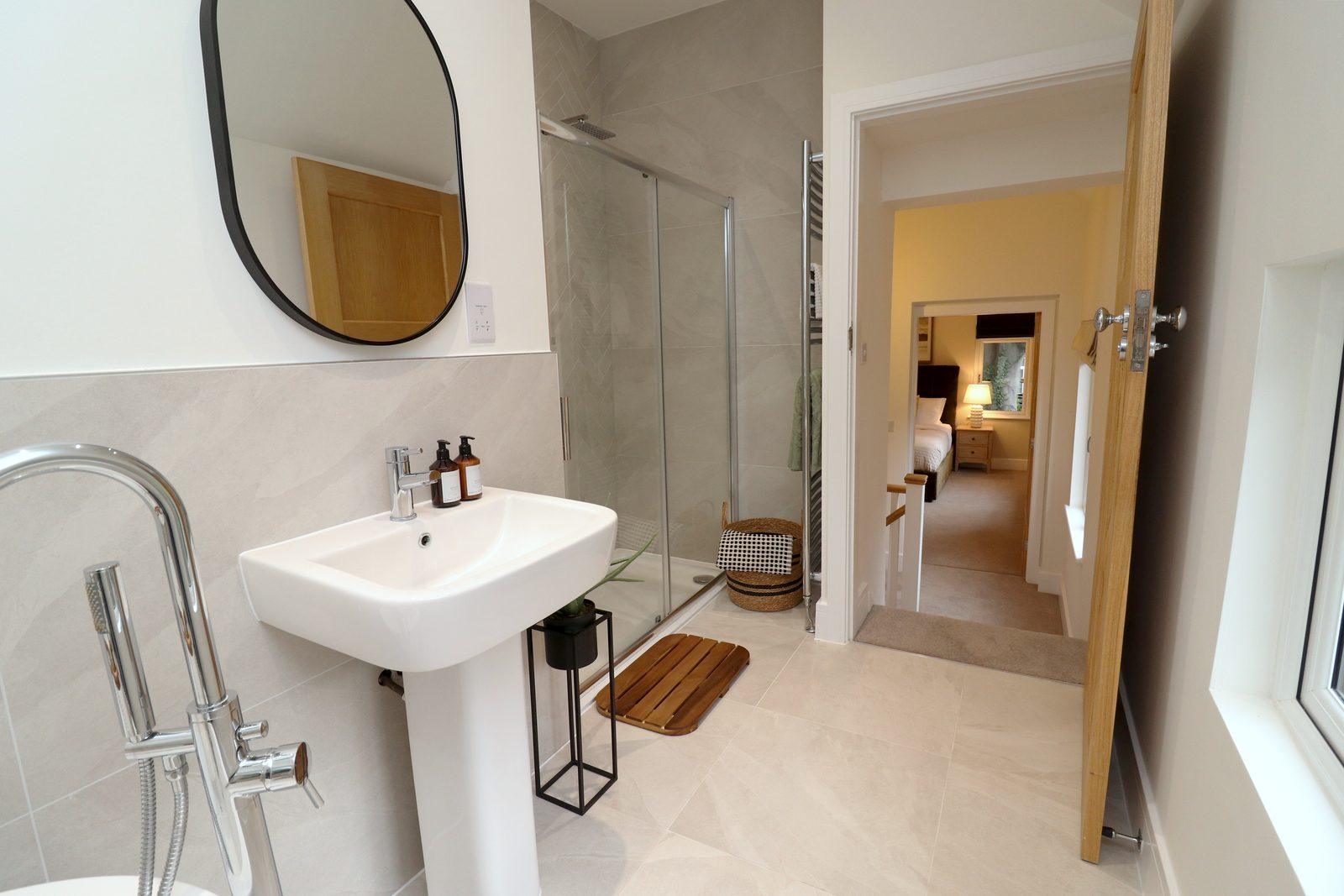 Basin, mirror and the shower, looking through to the landing