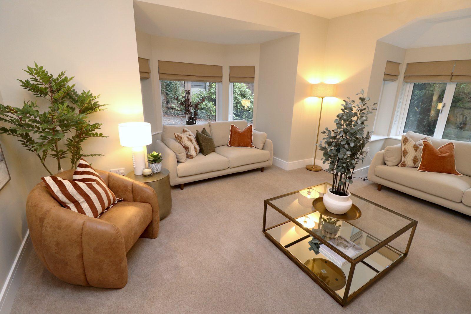 Leather armchair, lamp and sofa by the bay window