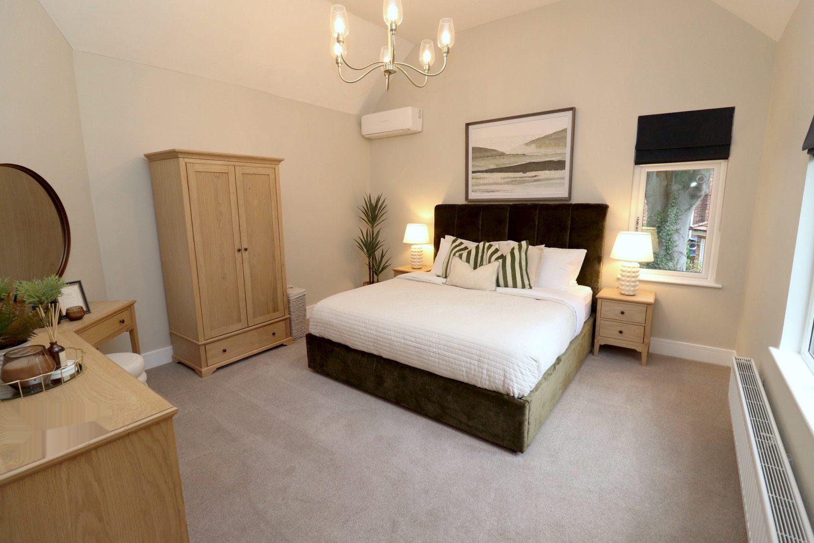 Main bedroom: olive velvet bed, oak wardrobe, dressing table and chandelier
