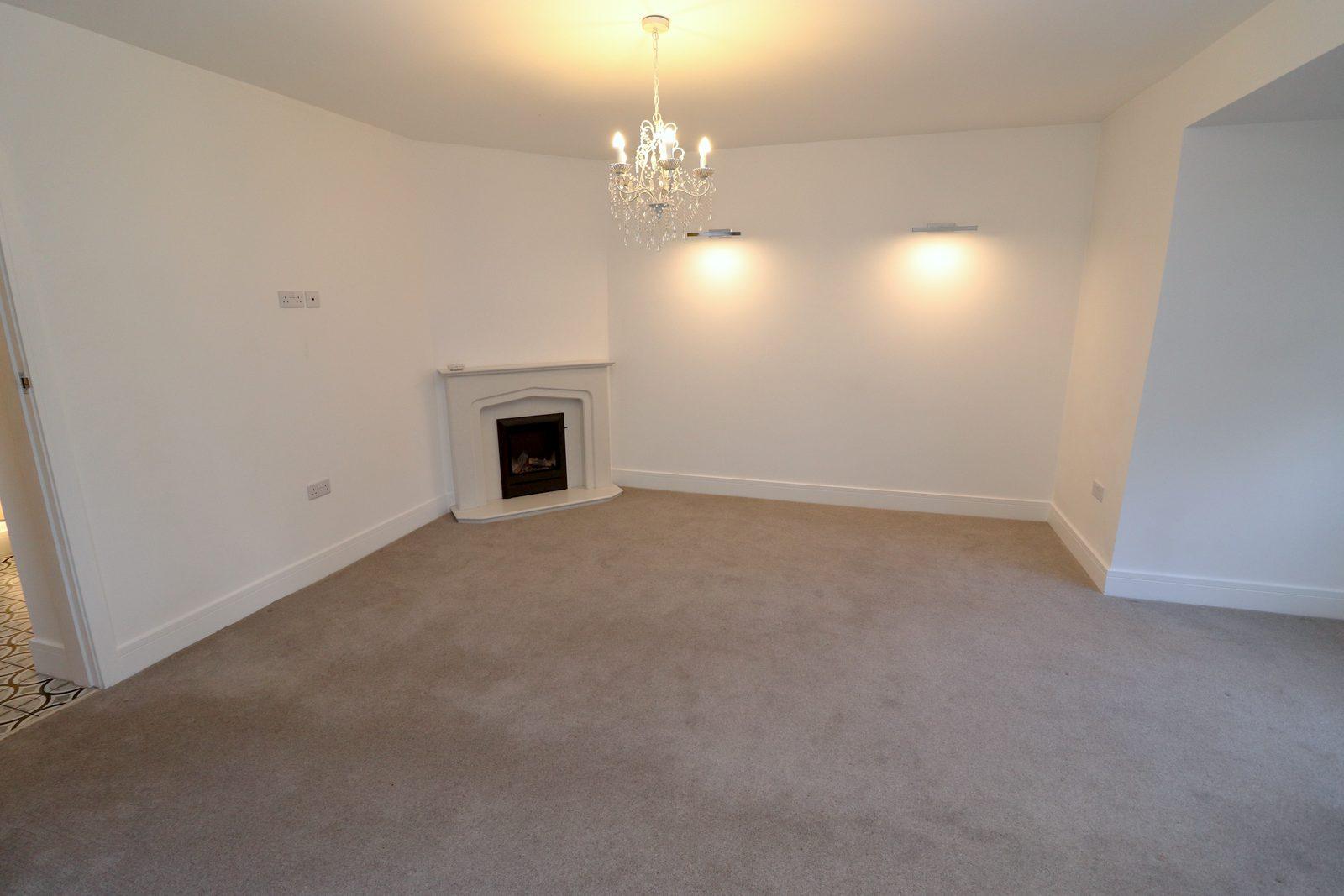 Living room before: bare walls and an unlit fireplace
